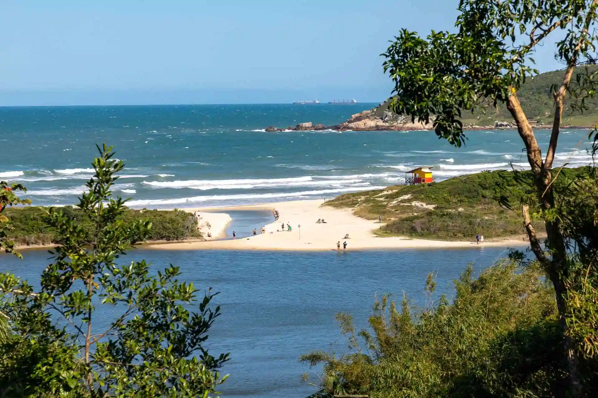 Vista panorâmica da Praia do Rosa em Santa Catarina com mar calmo e natureza preservada
